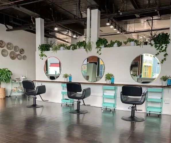 image shows the interior of Rena + Co. Hair Studio, featuring three styling stations